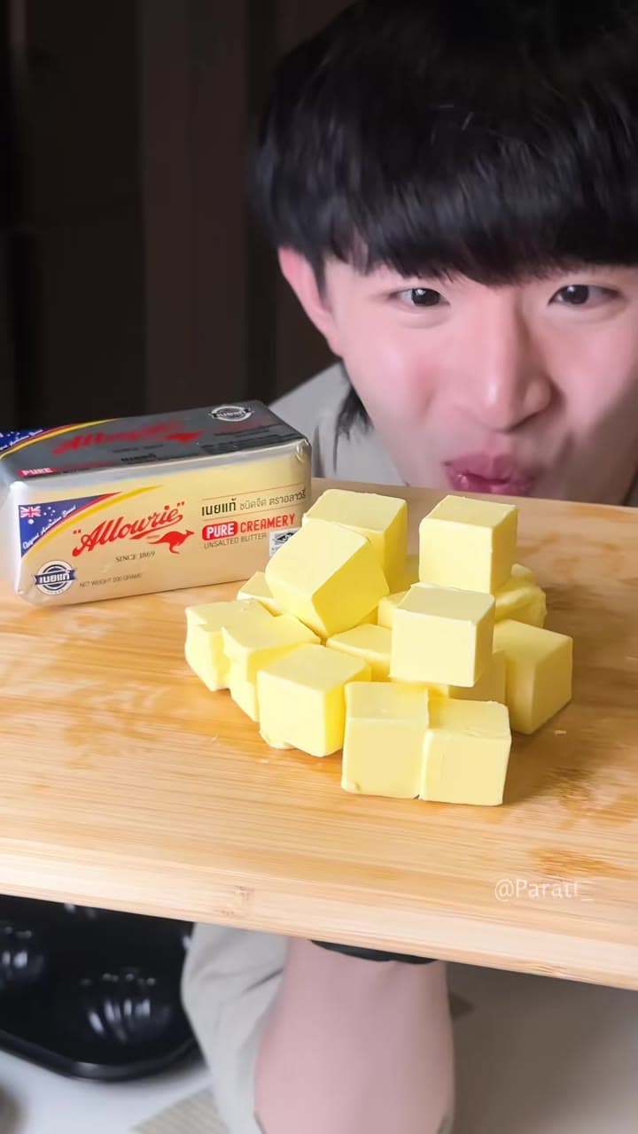 Ken Paratt ยิ้มกว้างเหนือเนยที่หั่นเป็นลูกเต๋า มีเนย Allowrie หนึ่งแพ็กวางข้างเขียง